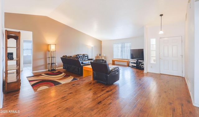 living room featuring lofted ceiling, wood finished floors, and baseboards