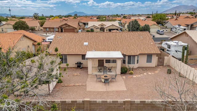 back of property with a residential view, stucco siding, a fenced backyard, and a tiled roof