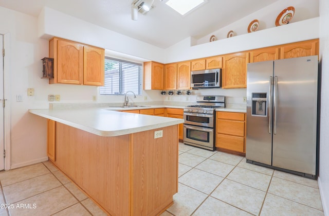 kitchen with stainless steel appliances, a sink, a peninsula, lofted ceiling, and light tile patterned flooring