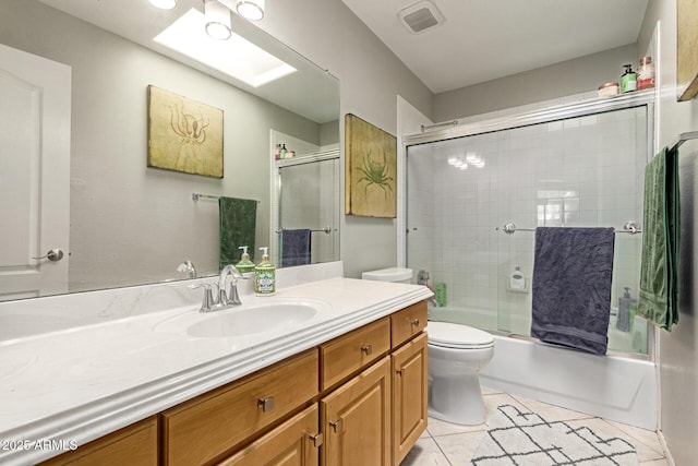 bathroom featuring visible vents, toilet, tile patterned flooring, combined bath / shower with glass door, and vanity