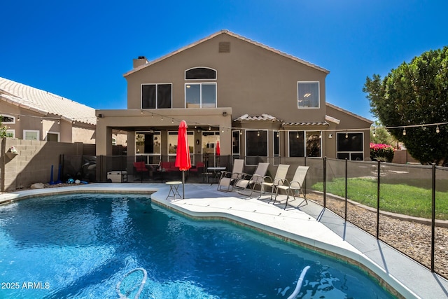 back of house featuring a fenced in pool, a patio, fence, and stucco siding