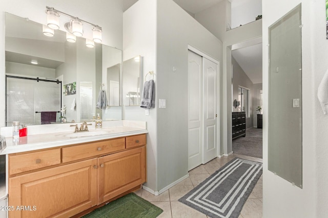 bathroom with baseboards, a shower stall, vanity, and tile patterned floors