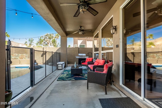 view of patio featuring a ceiling fan, fence, and an outdoor living space