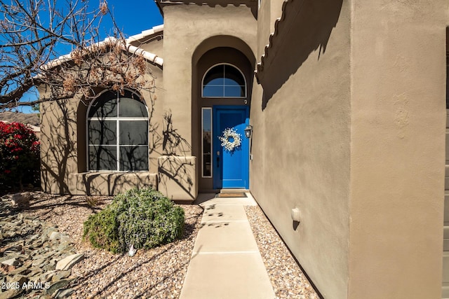 view of exterior entry featuring stucco siding