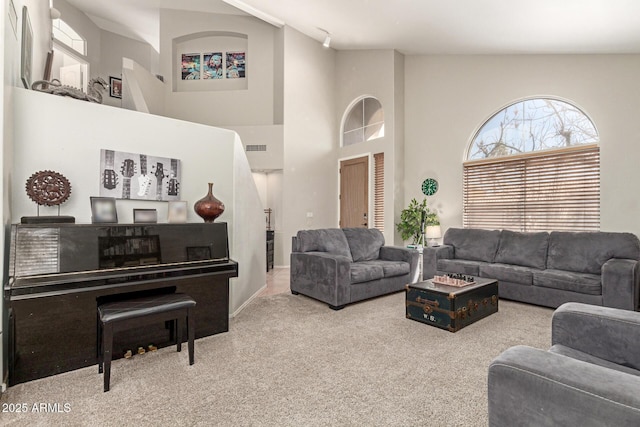 carpeted living area with visible vents and a towering ceiling