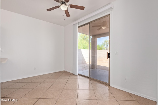 tiled empty room featuring ceiling fan