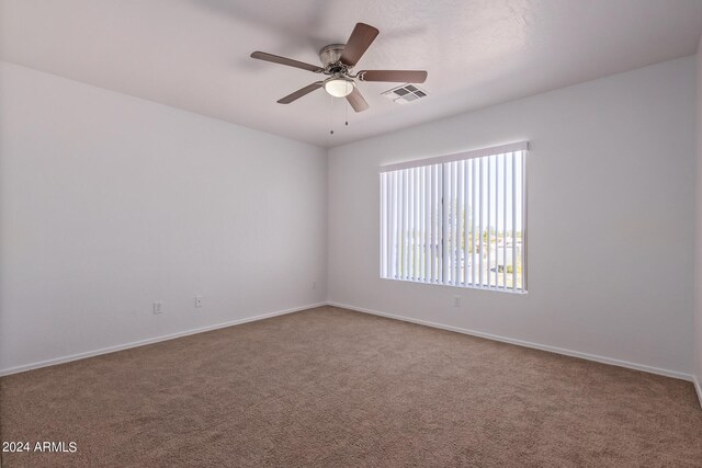 carpeted spare room featuring ceiling fan