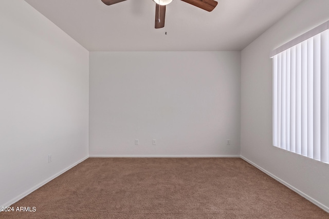 carpeted spare room with ceiling fan