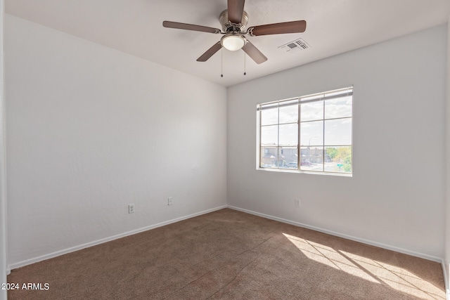 carpeted spare room featuring ceiling fan