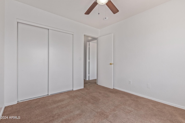 unfurnished bedroom with a closet, ceiling fan, and light colored carpet