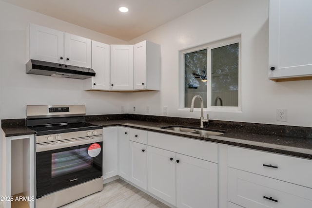 kitchen with white cabinetry, dark stone counters, sink, and stainless steel range with electric cooktop