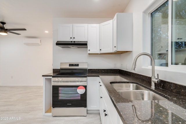 kitchen with sink, a wall mounted AC, white cabinets, dark stone counters, and electric range