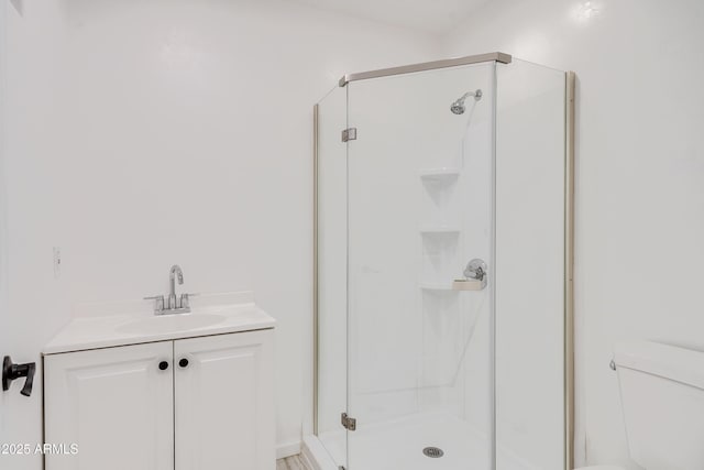 bathroom with walk in shower, vanity, and toilet