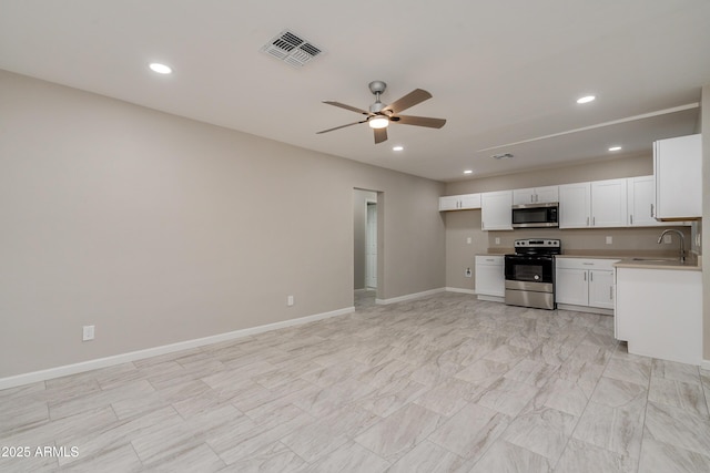 kitchen featuring stainless steel appliances, sink, white cabinets, and ceiling fan