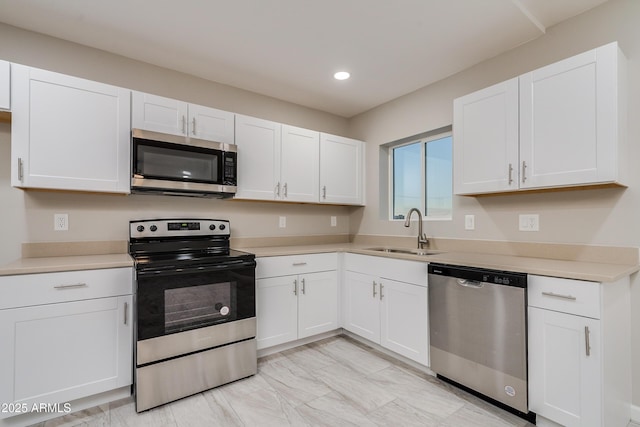 kitchen featuring stainless steel appliances, sink, and white cabinets