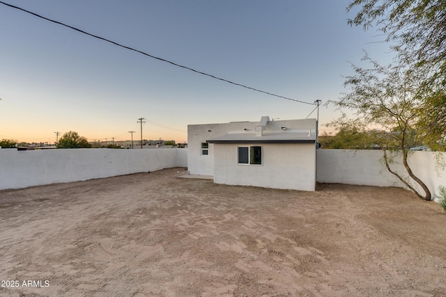 view of back house at dusk