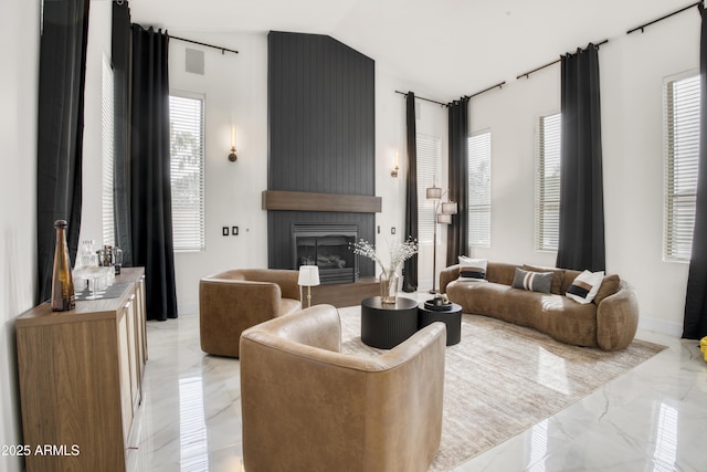 living area with a large fireplace, marble finish floor, lofted ceiling, and baseboards