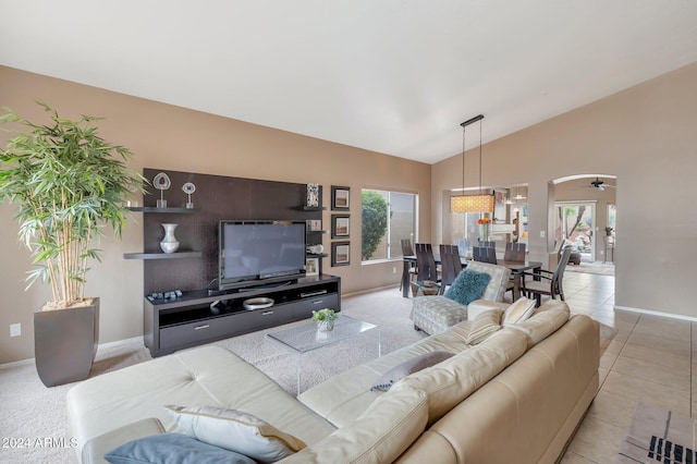 living room with ceiling fan, high vaulted ceiling, a healthy amount of sunlight, and light tile patterned flooring