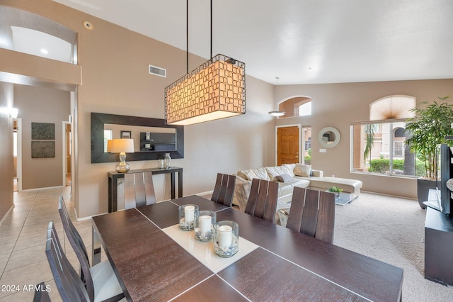 tiled dining room featuring high vaulted ceiling