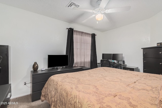 carpeted bedroom featuring ceiling fan and a textured ceiling