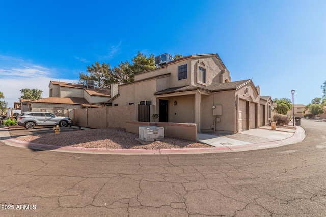 view of front of house with a garage and central AC