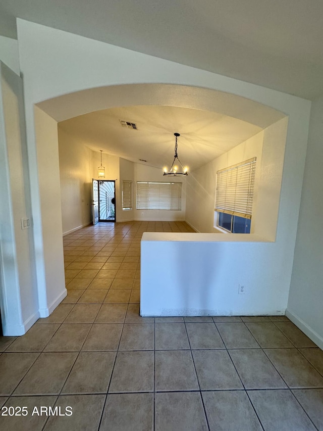 kitchen featuring hanging light fixtures, tile patterned flooring, lofted ceiling, and a chandelier