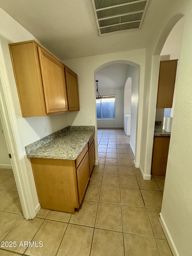 kitchen with light stone counters and light tile patterned flooring