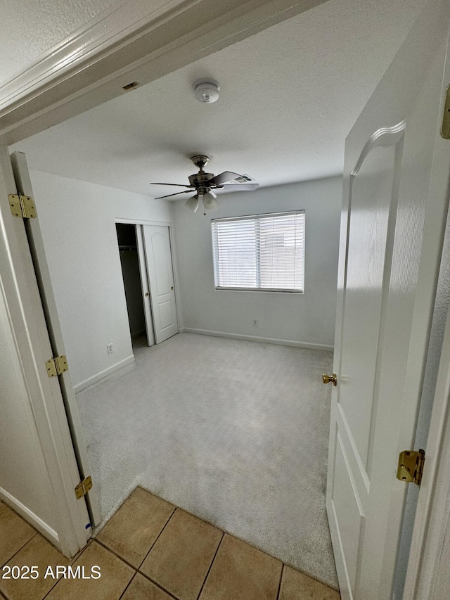 unfurnished room with ceiling fan and light carpet