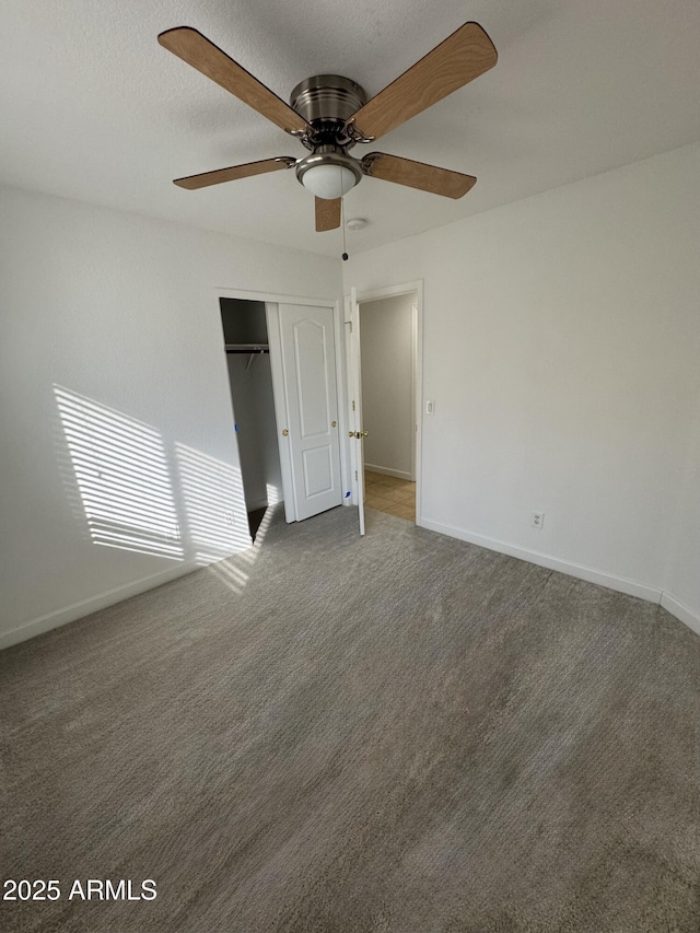 unfurnished bedroom with a closet, ceiling fan, and dark colored carpet