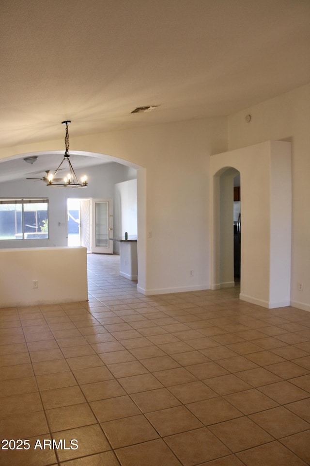 empty room featuring a chandelier and light tile patterned floors