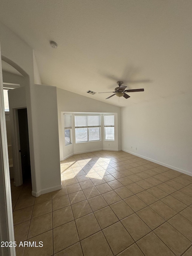 tiled spare room with lofted ceiling and ceiling fan