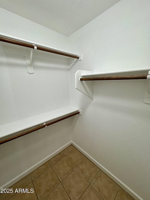 spacious closet with tile patterned floors