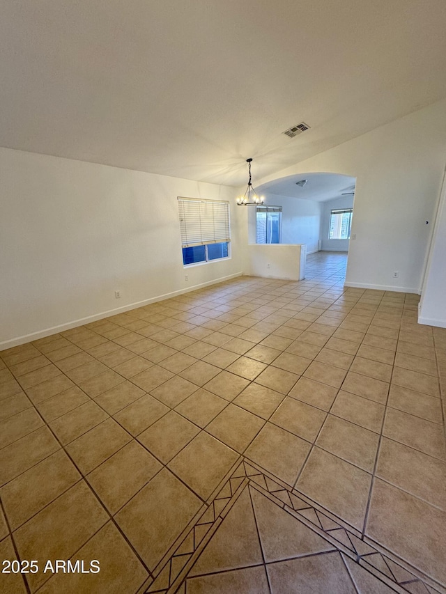 unfurnished living room with ceiling fan with notable chandelier and light tile patterned floors