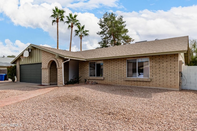 ranch-style house featuring an attached garage, roof with shingles, concrete driveway, and brick siding