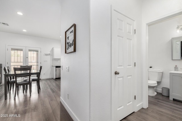 hall featuring recessed lighting, visible vents, baseboards, and dark wood-type flooring