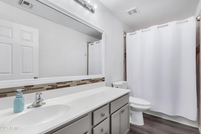 bathroom featuring tasteful backsplash, visible vents, vanity, and wood finished floors