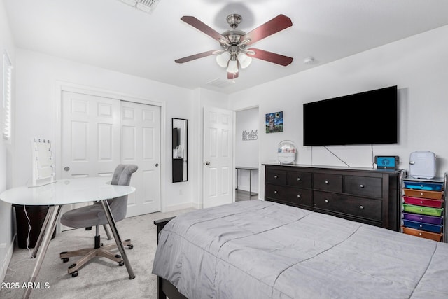 carpeted bedroom with a closet, baseboards, visible vents, and ceiling fan