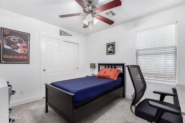 carpeted bedroom with baseboards, visible vents, a closet, and ceiling fan