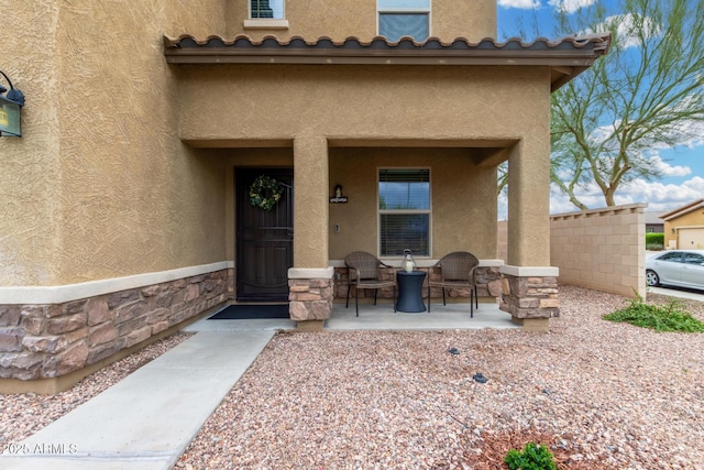 view of exterior entry with stone siding and stucco siding