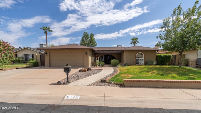 single story home with a garage and a front lawn