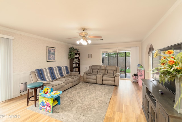 living room featuring light wood-type flooring, crown molding, and ceiling fan