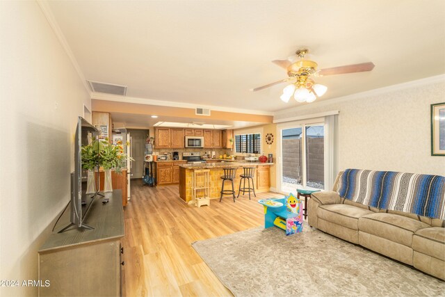 living room with crown molding, ceiling fan, and light hardwood / wood-style floors