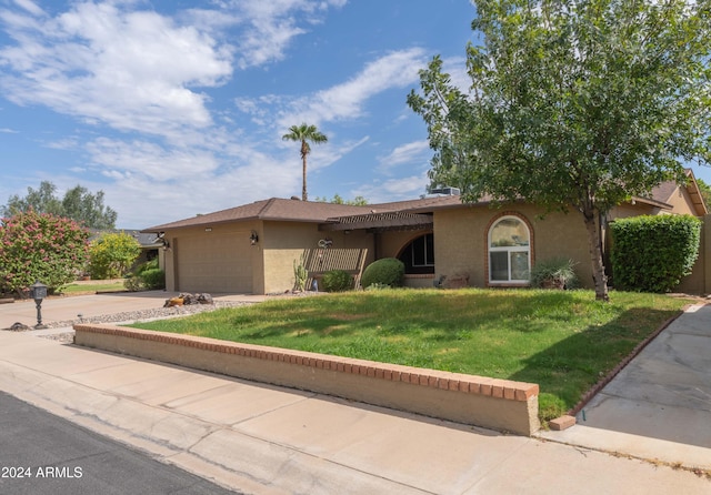 view of front of property featuring a garage and a front lawn