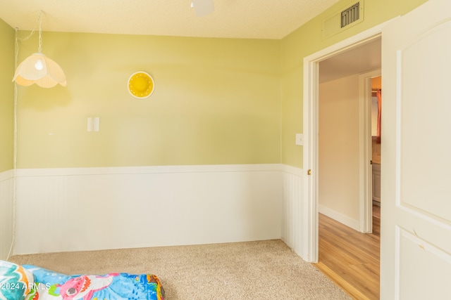 spare room featuring a textured ceiling and light wood-type flooring