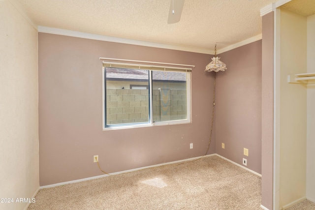 empty room featuring a textured ceiling, crown molding, carpet, and ceiling fan