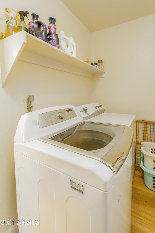 laundry room featuring light hardwood / wood-style floors and separate washer and dryer