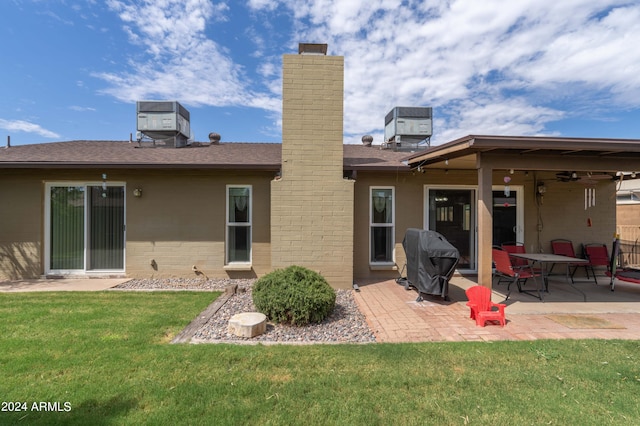 rear view of house featuring a yard, central AC, and a patio