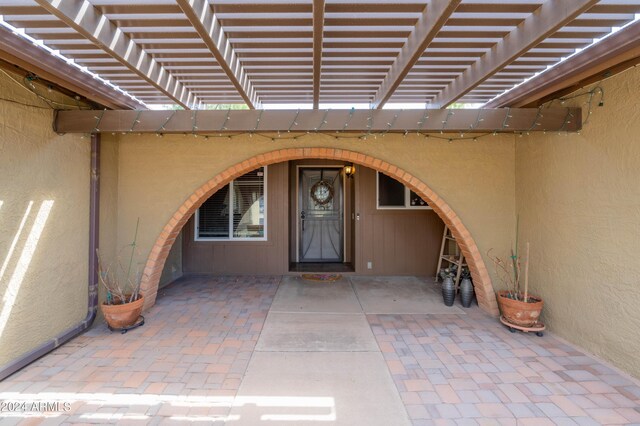 entrance to property with a patio area and a pergola