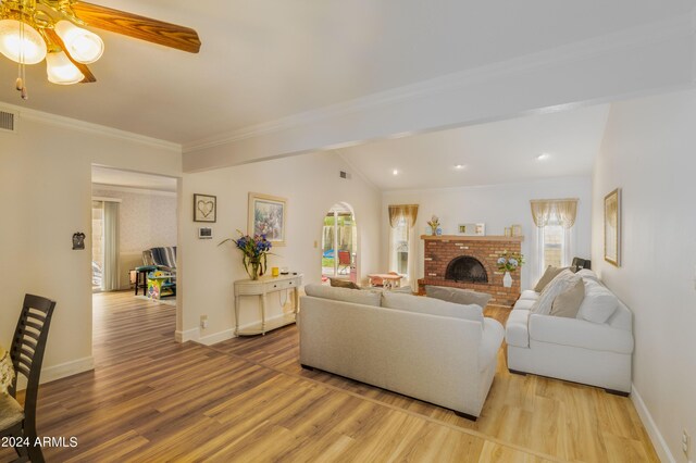 living room with lofted ceiling, light hardwood / wood-style flooring, ceiling fan, and a fireplace