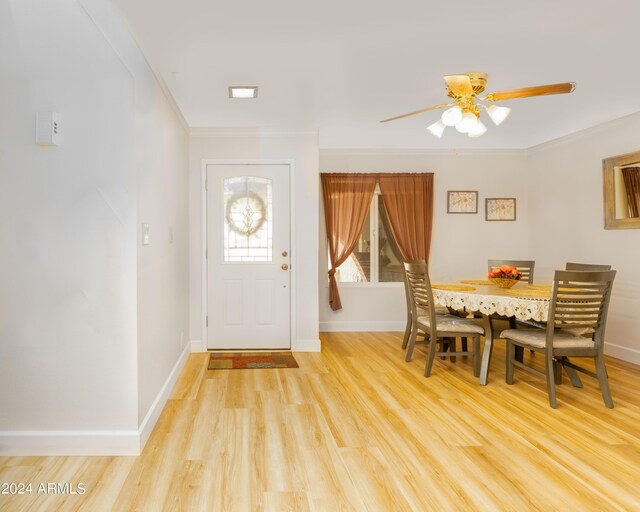 foyer with ceiling fan, ornamental molding, and light hardwood / wood-style floors